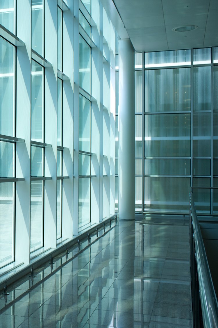 Glass curtain wall lining a bright interior walkway