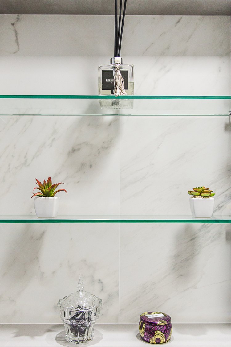 Floating glass shelves on a marble wall