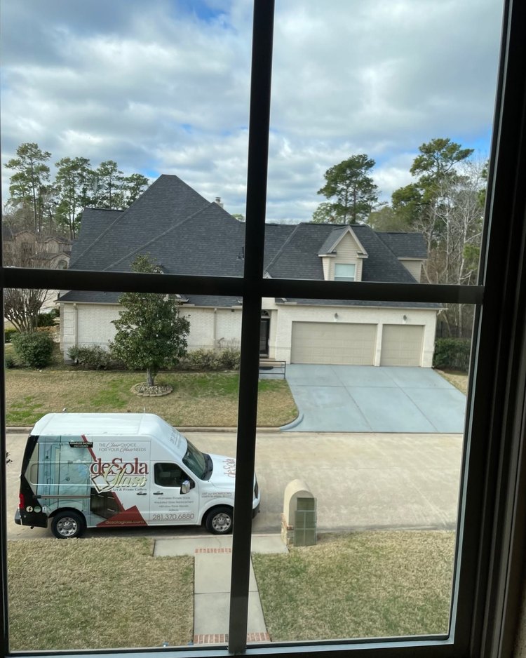 DeSola van parked outside a home seen through a window