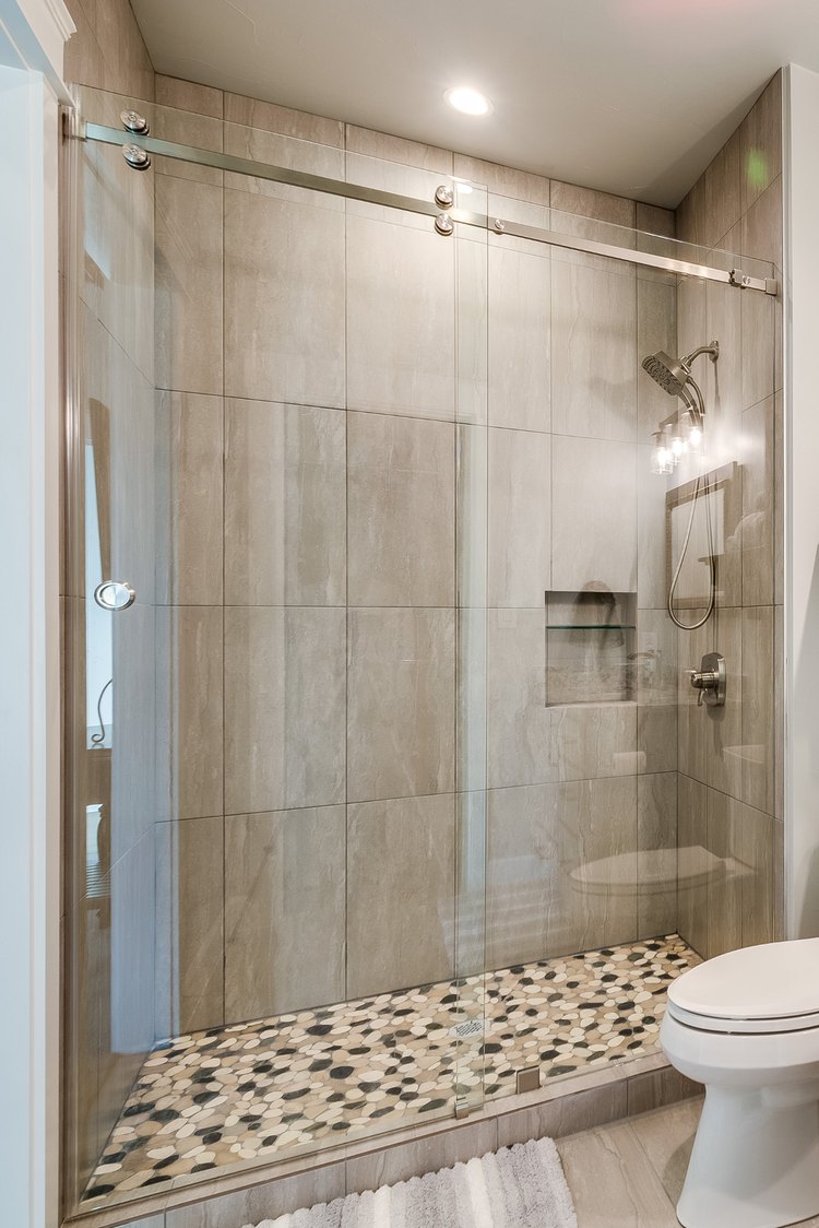 Sliding glass shower door over a tiled shower