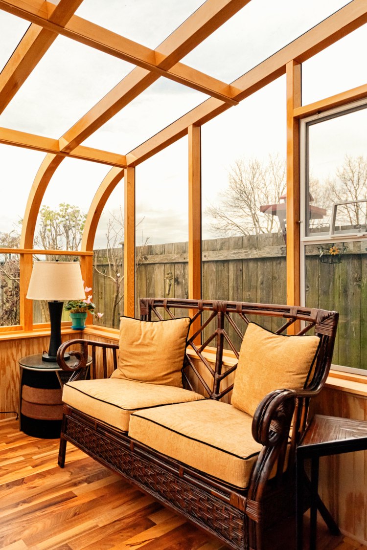 Wood framed glass sunroom with patio seating