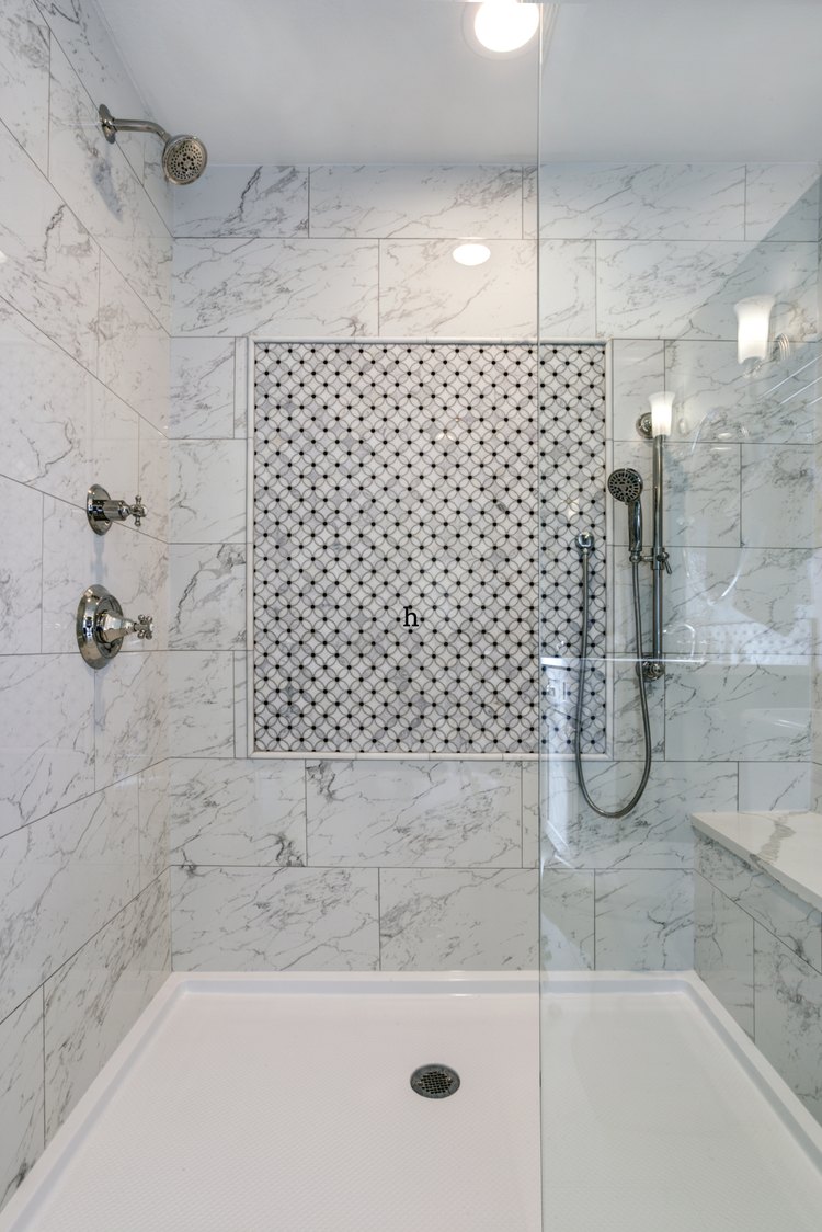 Walk-in glass shower with marble tile